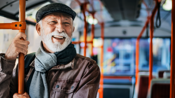 Senior mit weißem Bart stehend im Bus